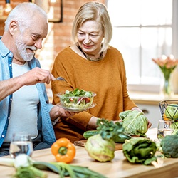A cheerful older couple eating a salad together