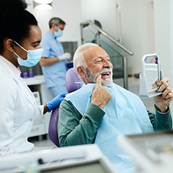 Patient looking at reflection in handheld mirror