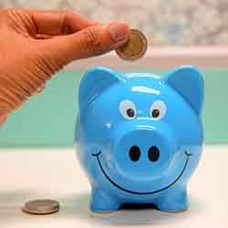 Hand putting coin in piggy bank